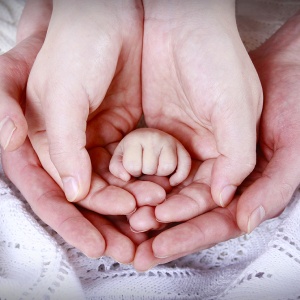 mani di genitori e neonato appena nato